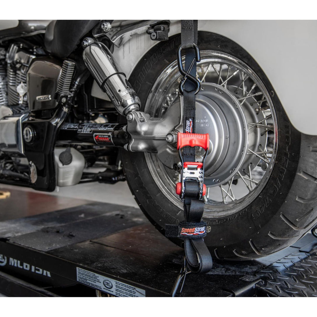 Motorcycle wheel with a speed strap tie down on a flatbed truck