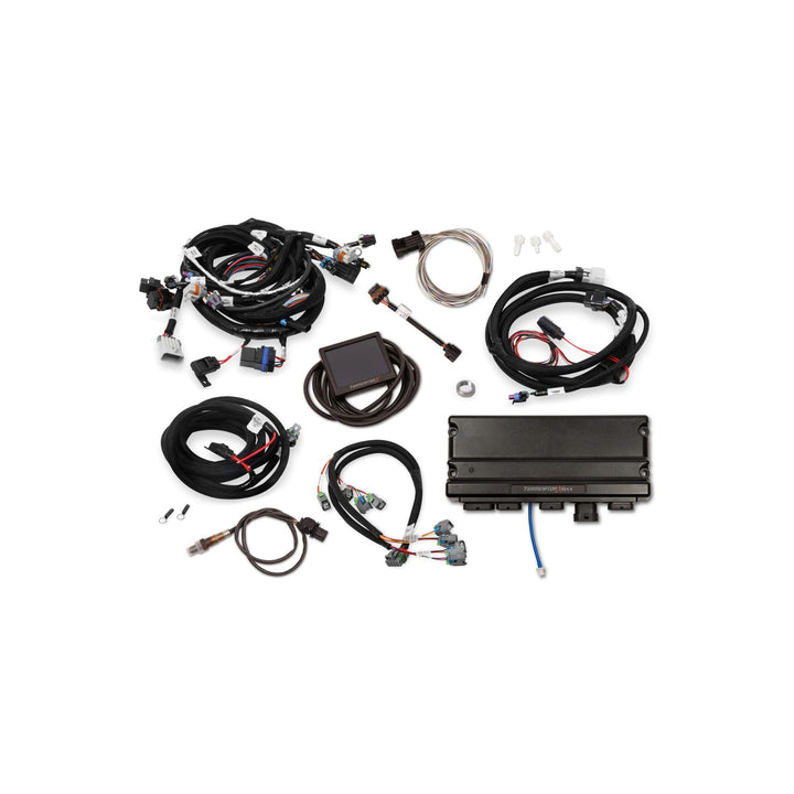 An Holley Terminator X Max Gen IV LS kit laid out on a plain white background, including multiple black coiled wires, connectors, a rectangular control module, small hardware pieces, and a metal probe wire.