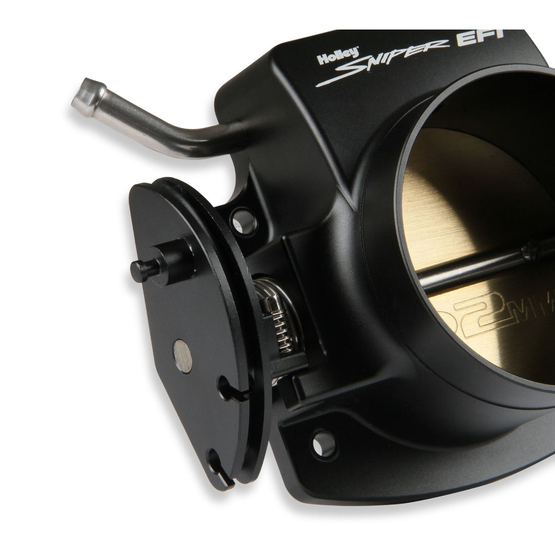 A Holley Sniper EFI billet throttle body for GM LS engine in black anodized metal, featuring a silver lever and a gold-colored butterfly disc inside the open intake port, shown on a white background.