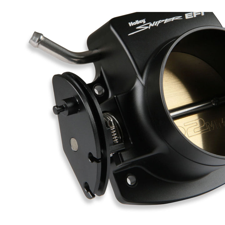 A Holley Sniper EFI billet throttle body for GM LS engine in black anodized metal, featuring a silver lever and a gold-colored butterfly disc inside the open intake port, shown on a white background.