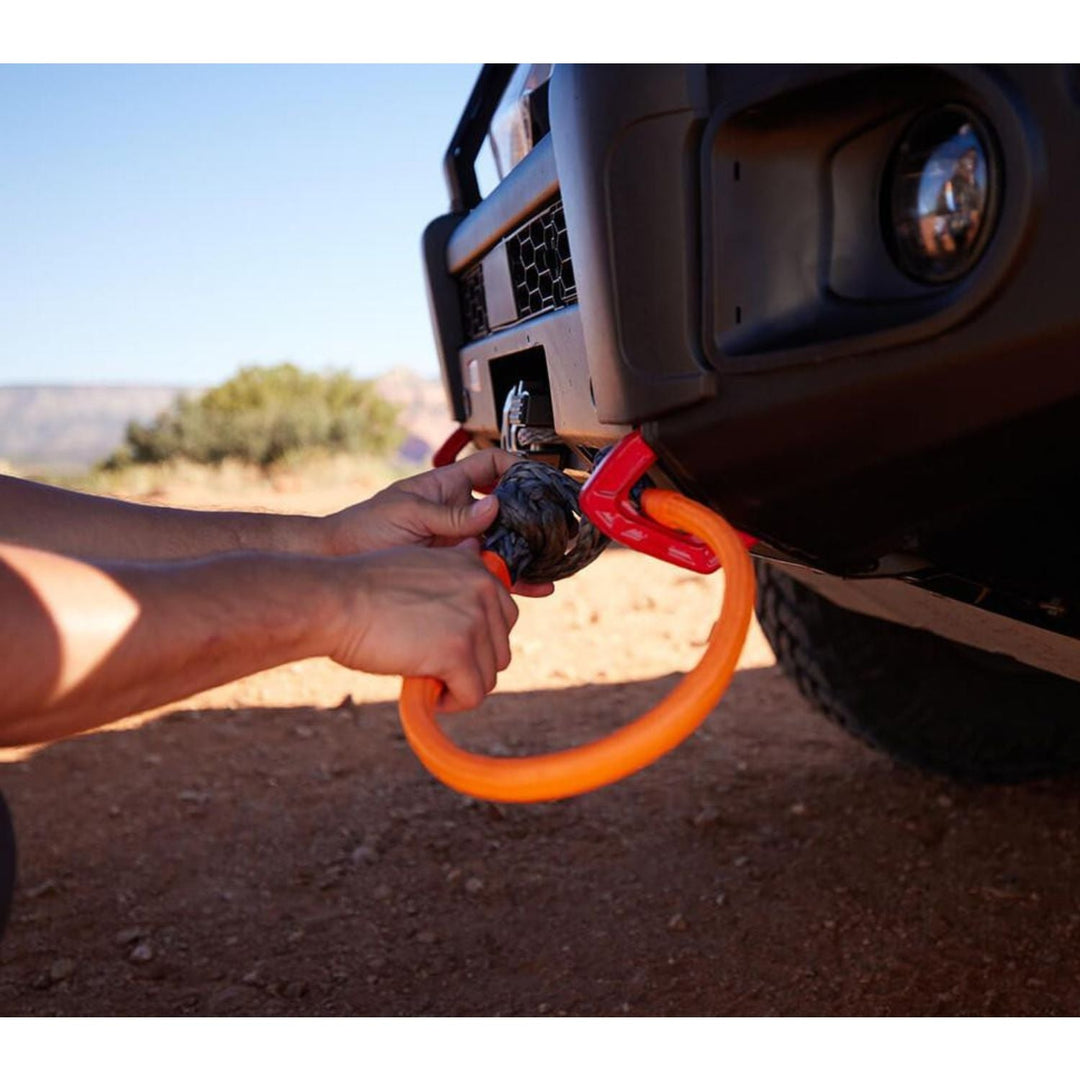 Person using an orange ARB recovery shackle for 4x4 vehicles in a desert setting