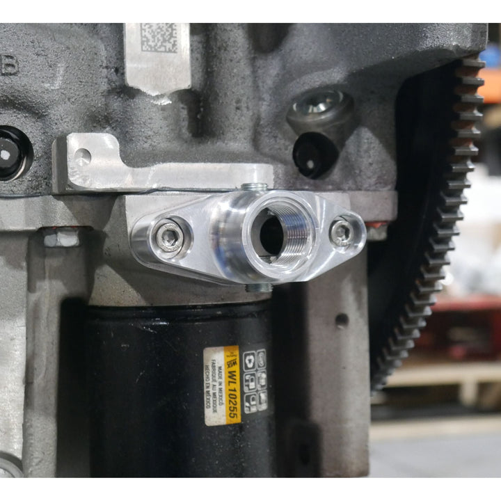 Close-up of a LT1 LT4 oil accumulator port adapter in use on an engine.
