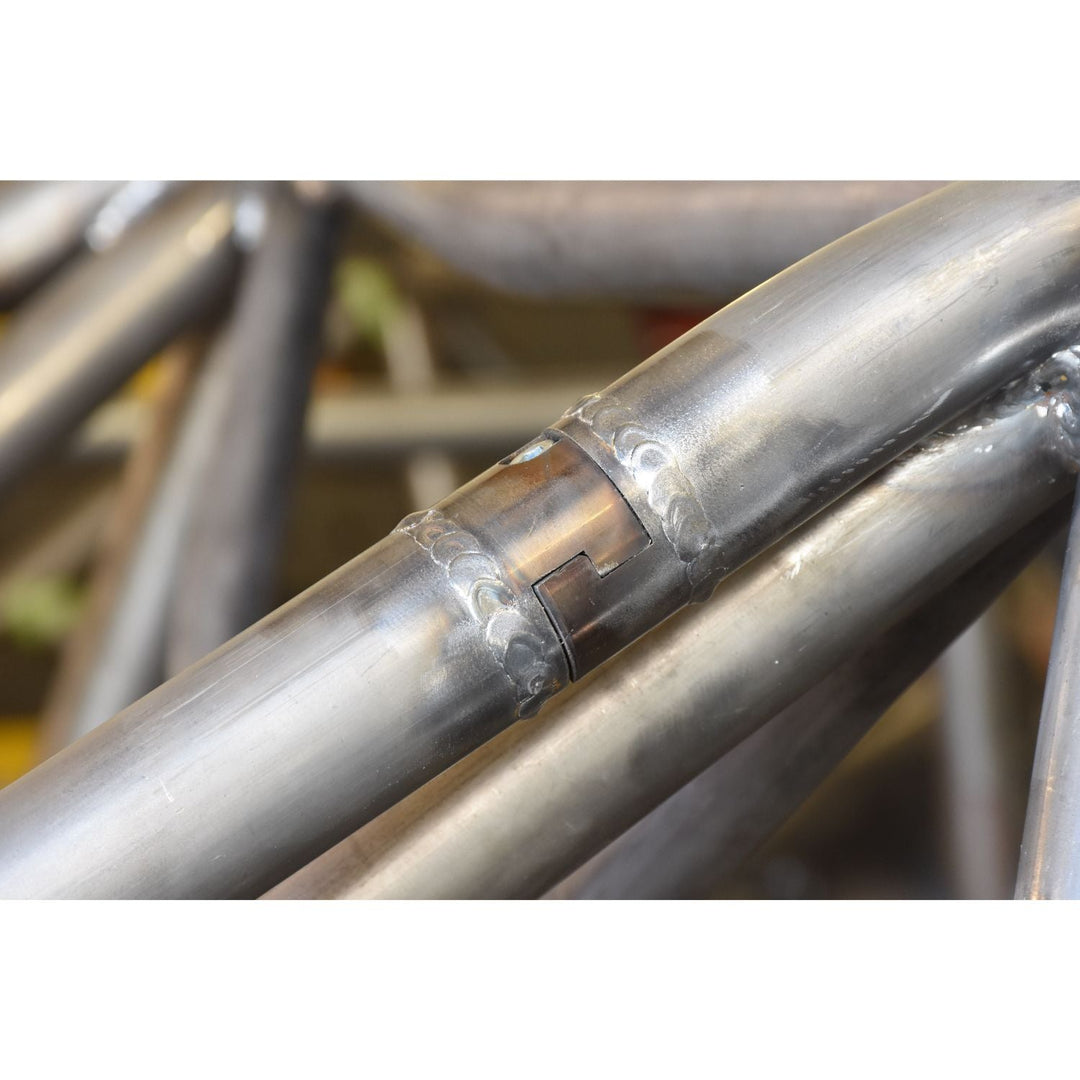 Close-up of a metal chassis with a chromoly interlocking tube disconnect on a blurred background