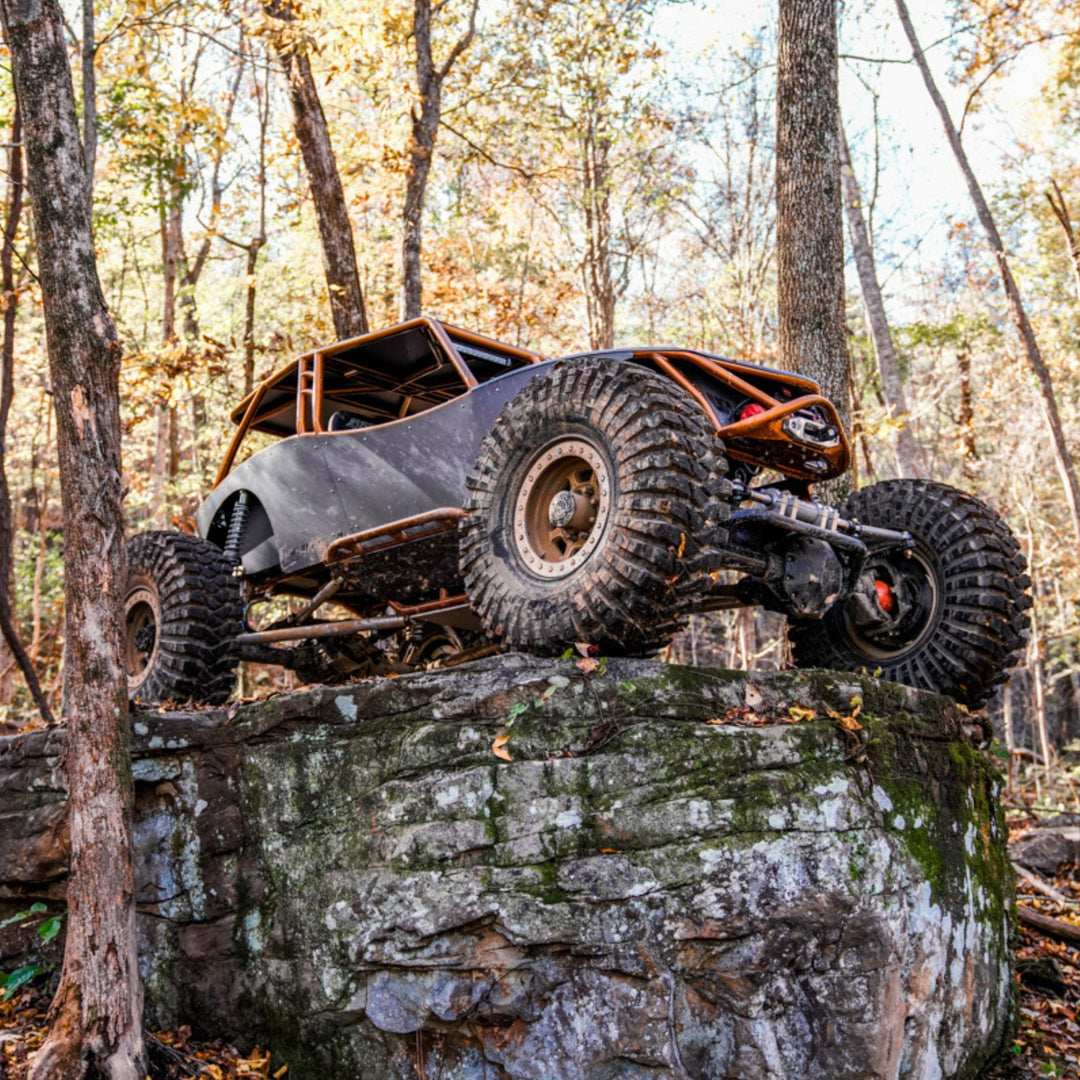 Off-road vehicle with revolution tube chassis a rocky outcrop in a forest