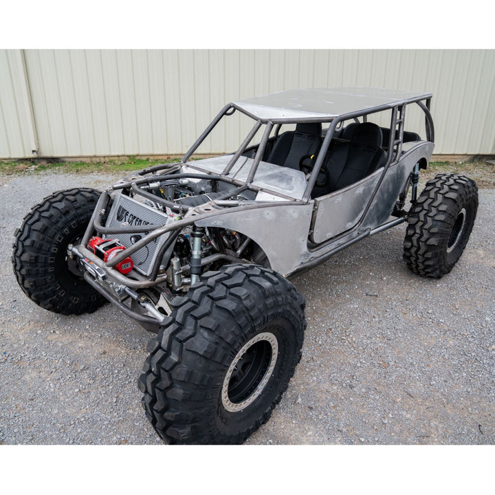 rock crawler with tube chassis and large tires on a concrete surface.