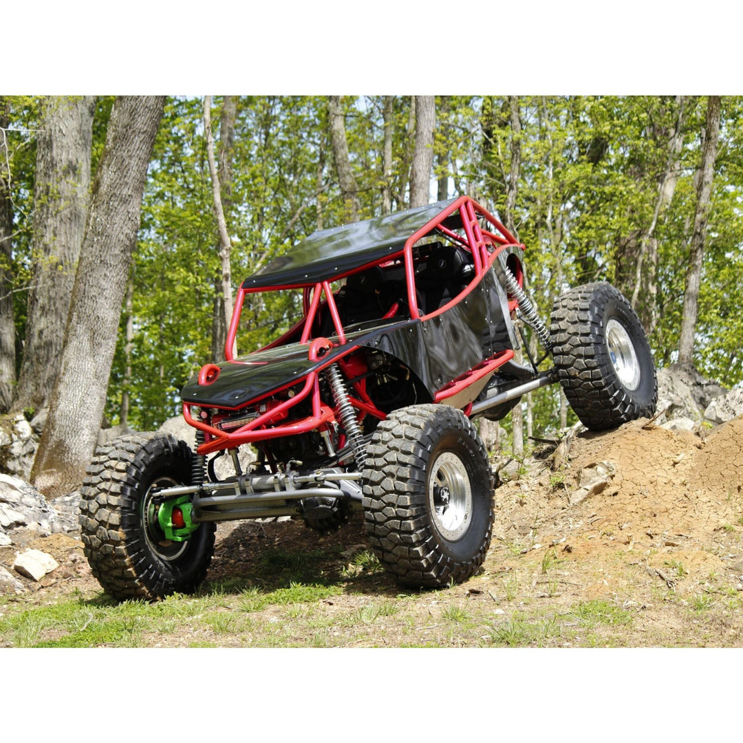 evolution rc crawler vehicle climbing a small hill in a forested area