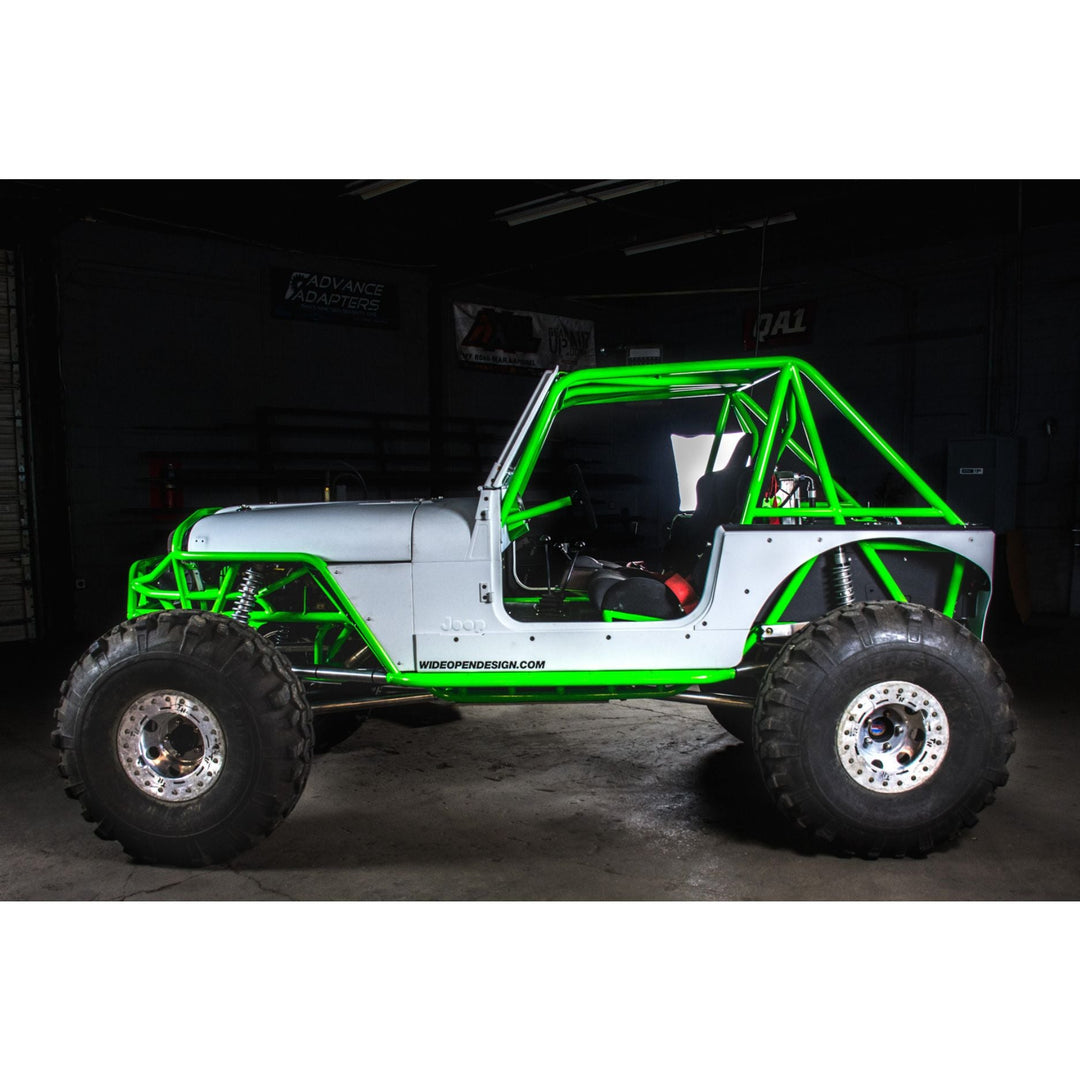 Green and white Jeep JC Chassis build with tube frame in a dark indoor setting