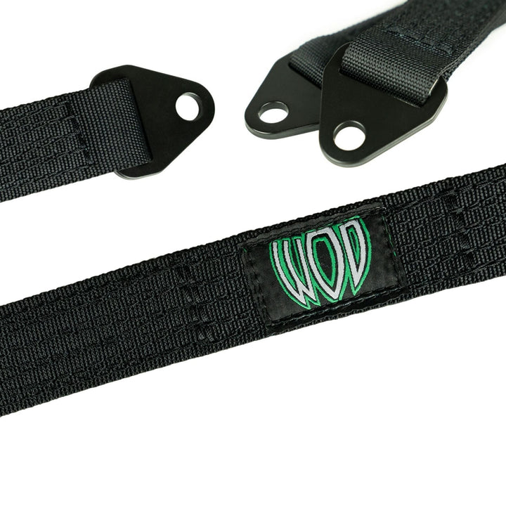 Black quad wrapped suspension limit straps with a green and white Wide Open Design logo on a white background